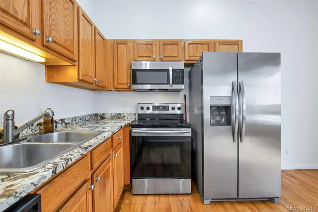 a kitchen with a refrigerator sink and cabinets