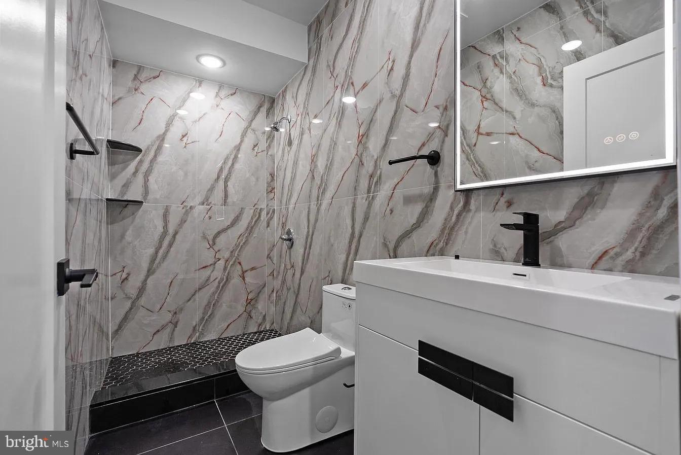 a bathroom with a sink a toilet and shower