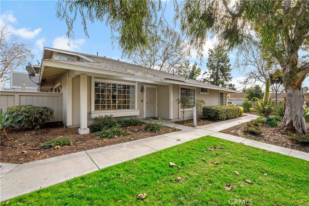 a view of a house with a yard and palm trees
