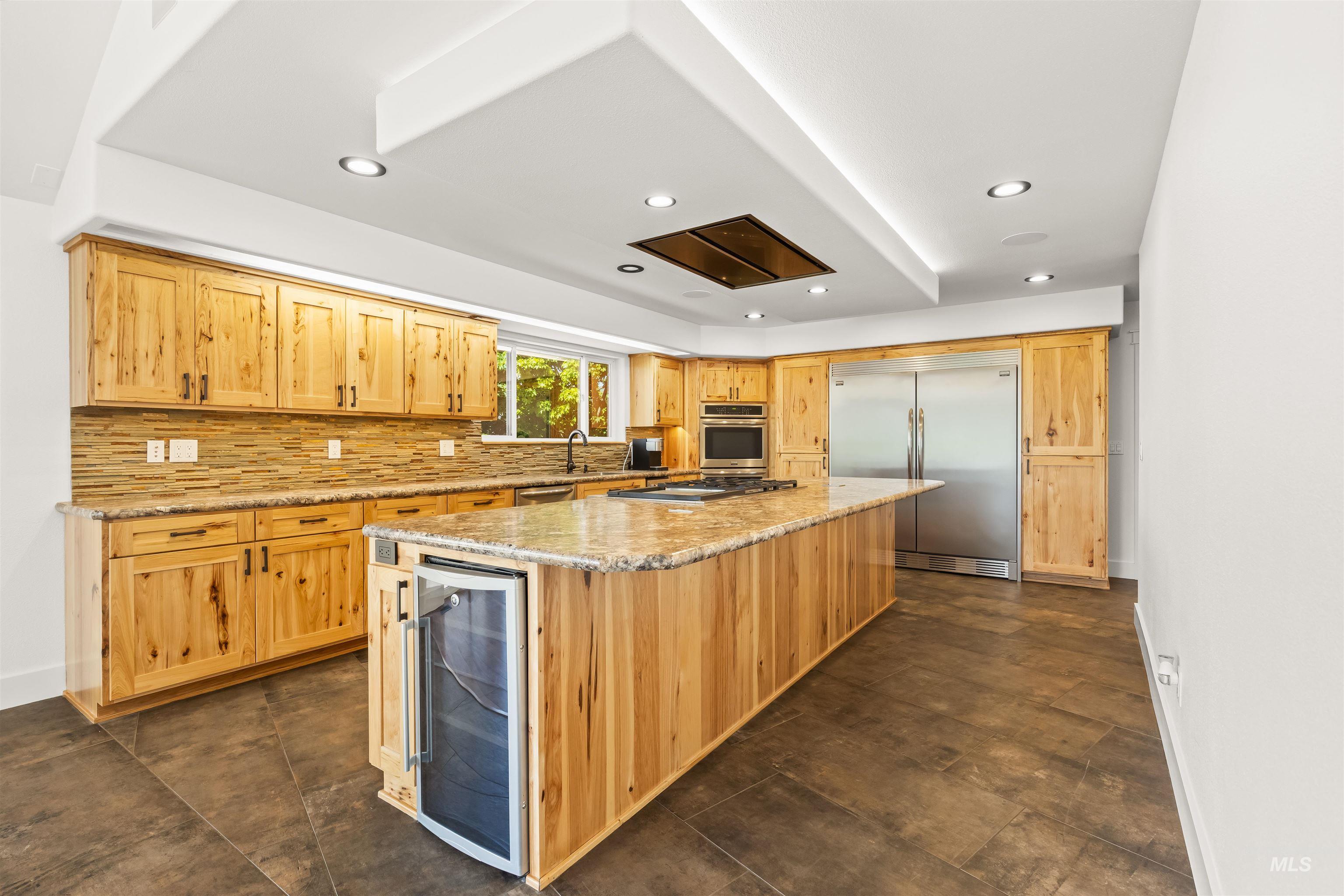 3360 East Main Street Lewiston, ID 83501 - Photo 13 of 50 Kitchen featuring extensive light wood cabinetry, stone-finish countertops, stainless steel appliances, a center island with a built-in beverage cooler, and recessed lighting