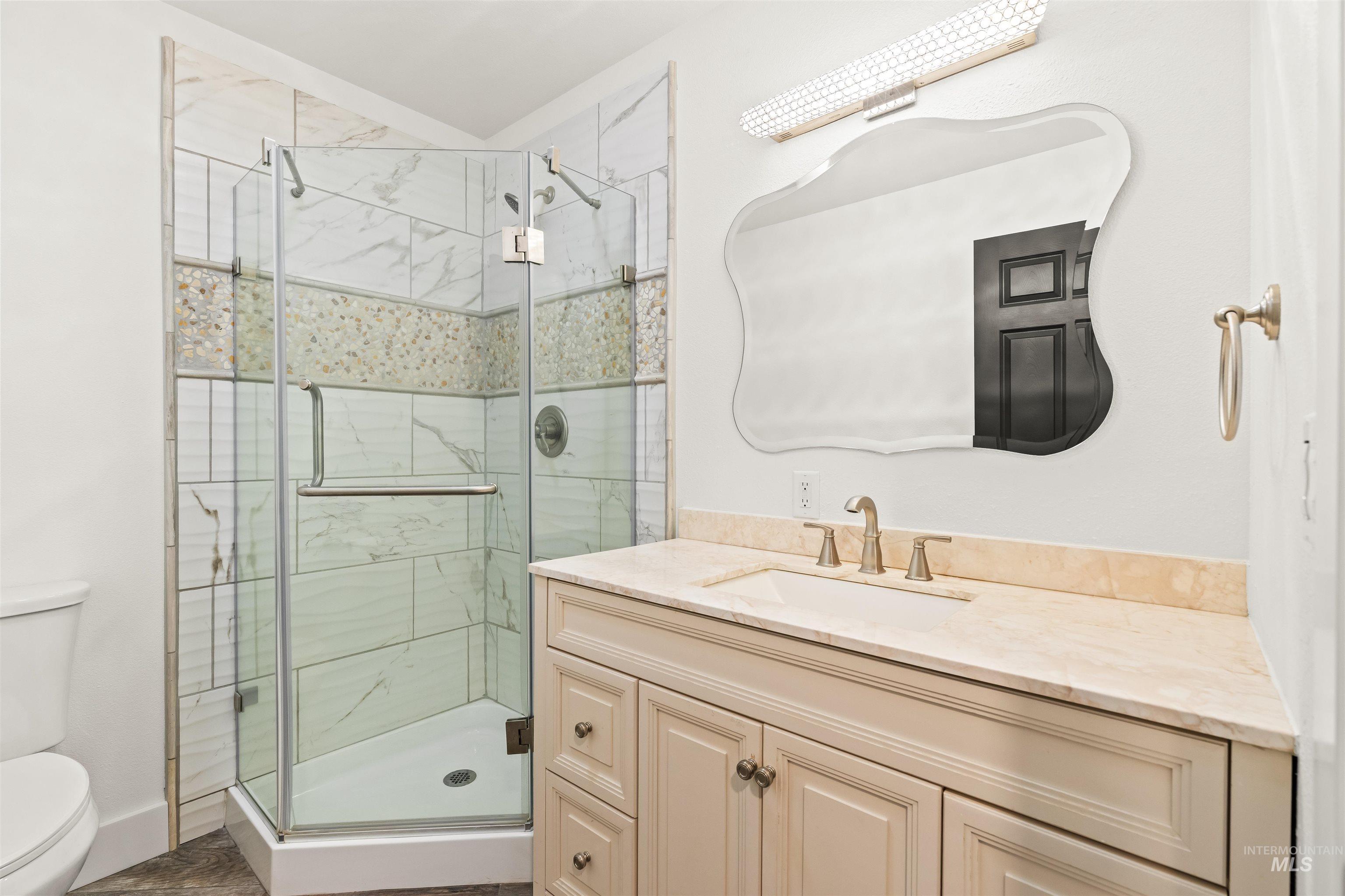 3360 East Main Street Lewiston, ID 83501 - Photo 20 of 50 Glass-enclosed corner shower with natural stone-look tiling and mosaic accent band