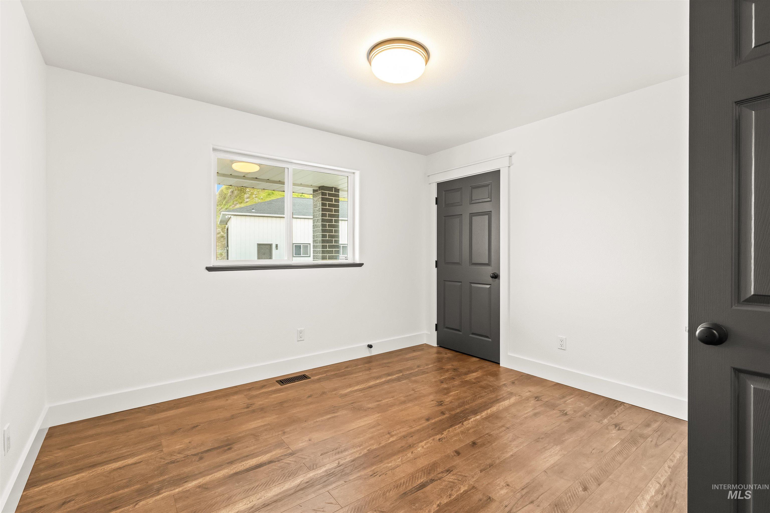 3360 East Main Street Lewiston, ID 83501 - Photo 21 of 50 Bright interior room featuring wood-finish flooring, white walls, and a window with black trim