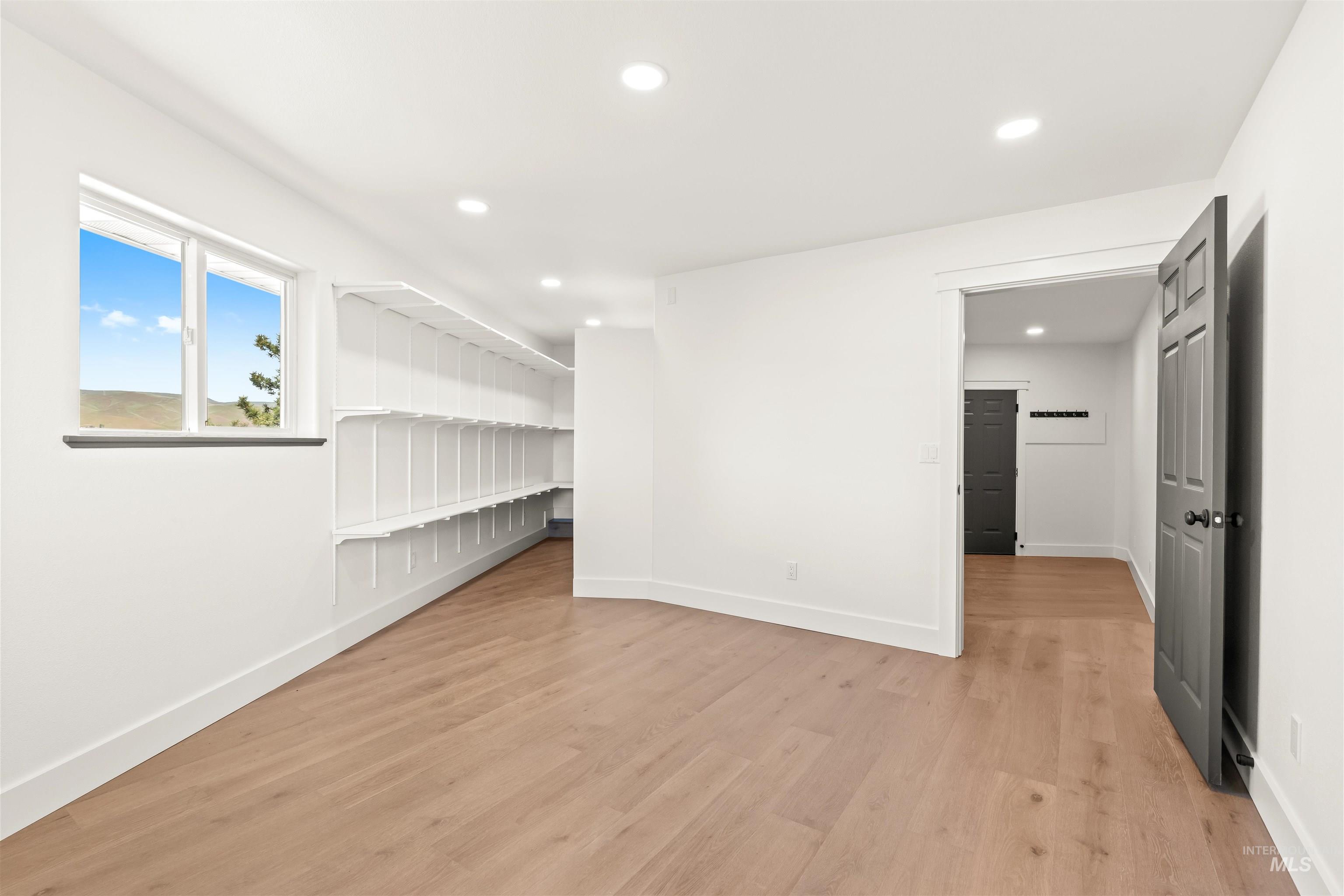 3360 East Main Street Lewiston, ID 83501 - Photo 22 of 50 Spacious room featuring extensive built-in shelving, wood-finish flooring, recessed lighting, and a white-framed window