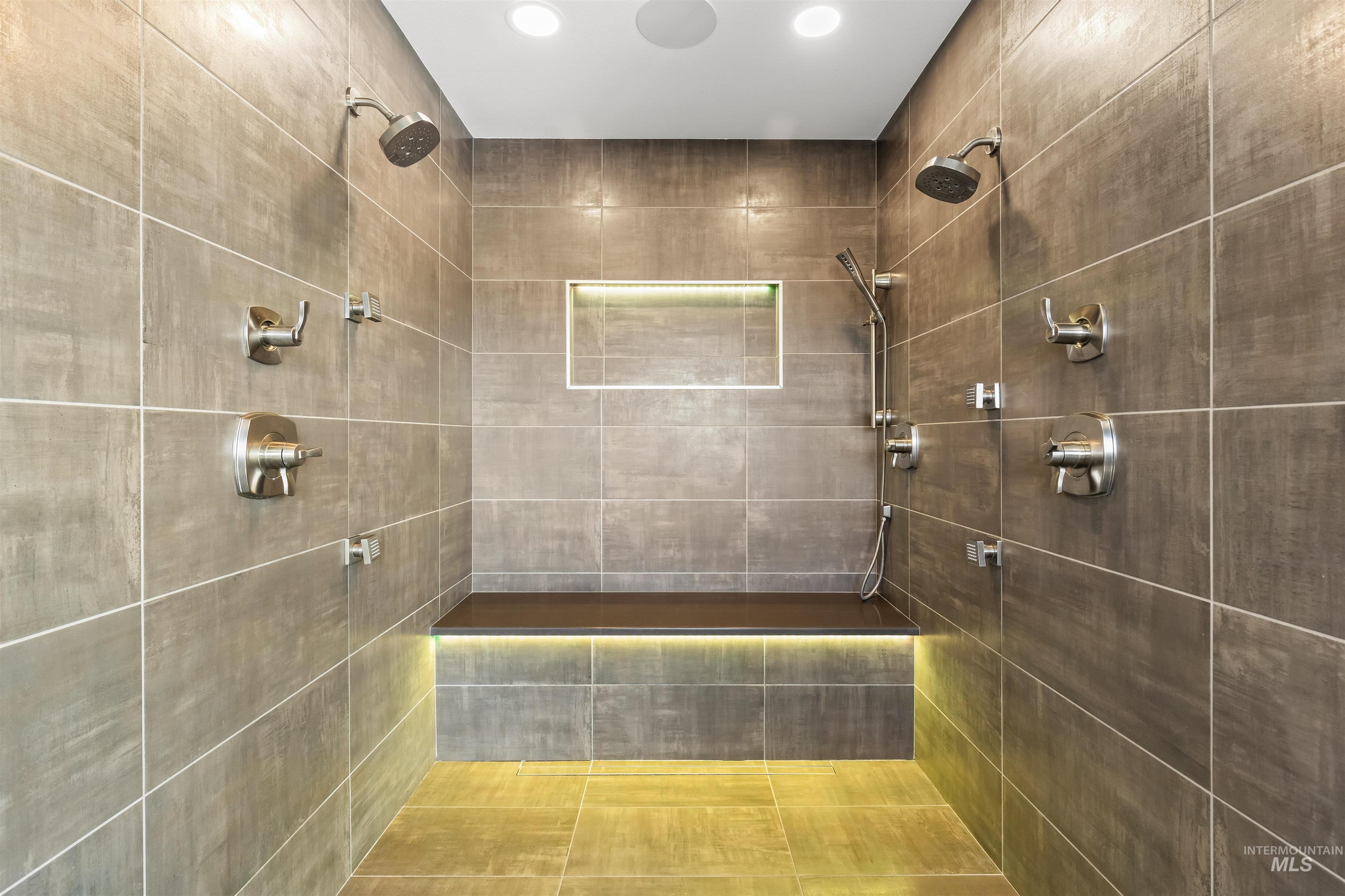 3360 East Main Street Lewiston, ID 83501 - Photo 29 of 50 Spacious walk-in shower featuring large format tile, dual shower heads, a built-in bench with accent lighting, and an illuminated recessed niche