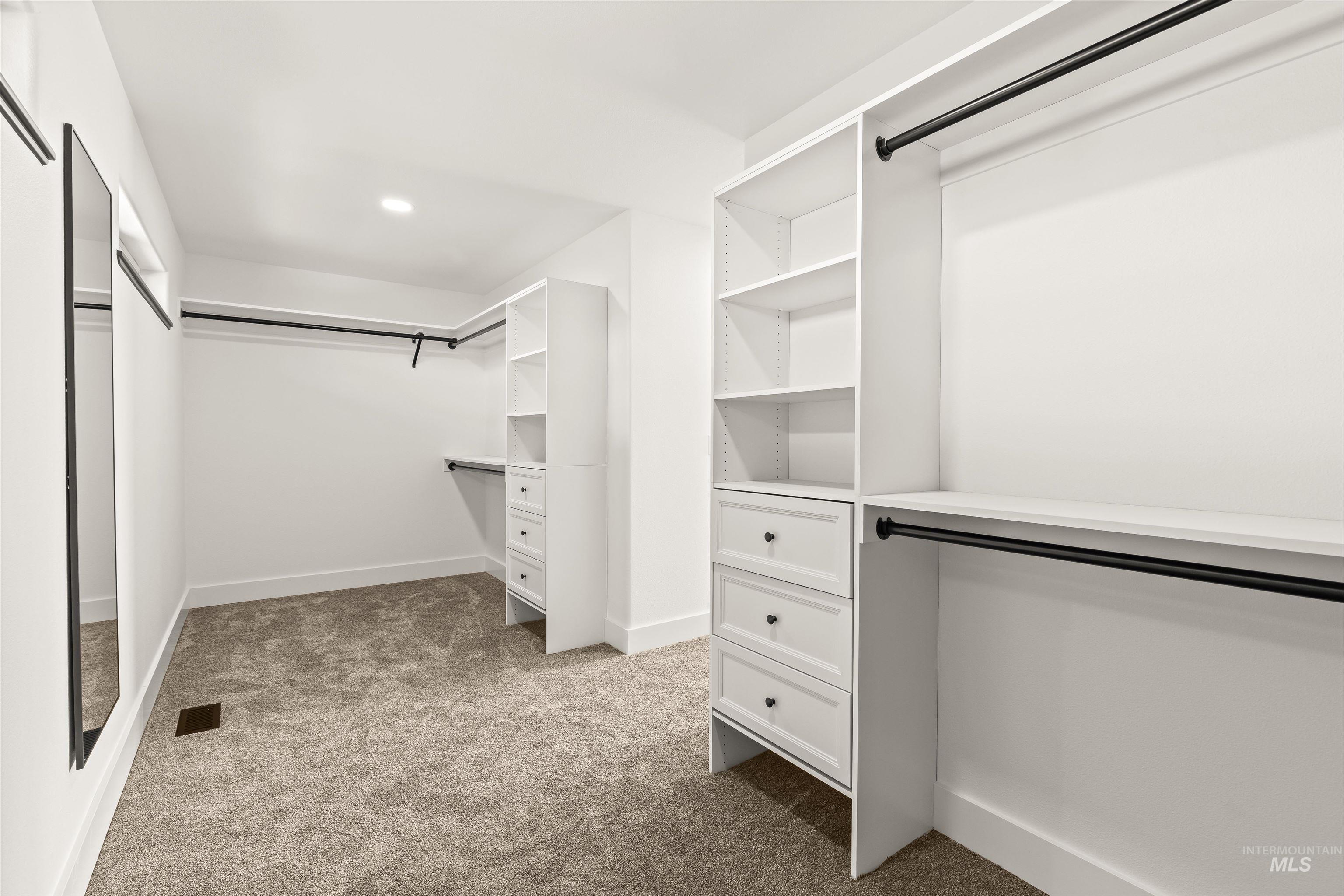 3360 East Main Street Lewiston, ID 83501 - Photo 32 of 50 Walk-in closet featuring built-in white shelving, integrated drawers, dark hanging rods, recessed ceiling lighting, and soft carpet flooring