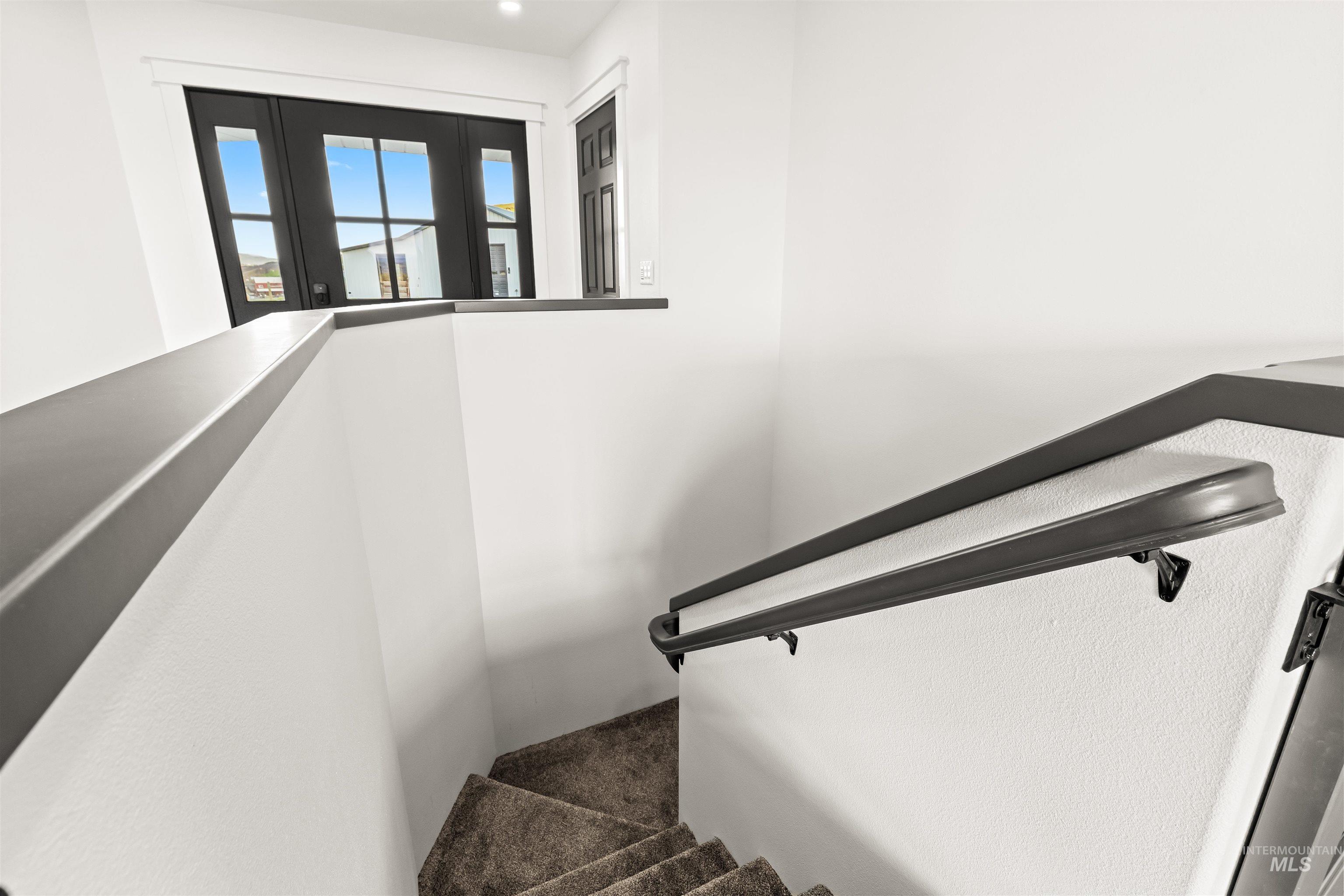 3360 East Main Street Lewiston, ID 83501 - Photo 35 of 50 Carpeted staircase with dark handrails and a half-wall partition