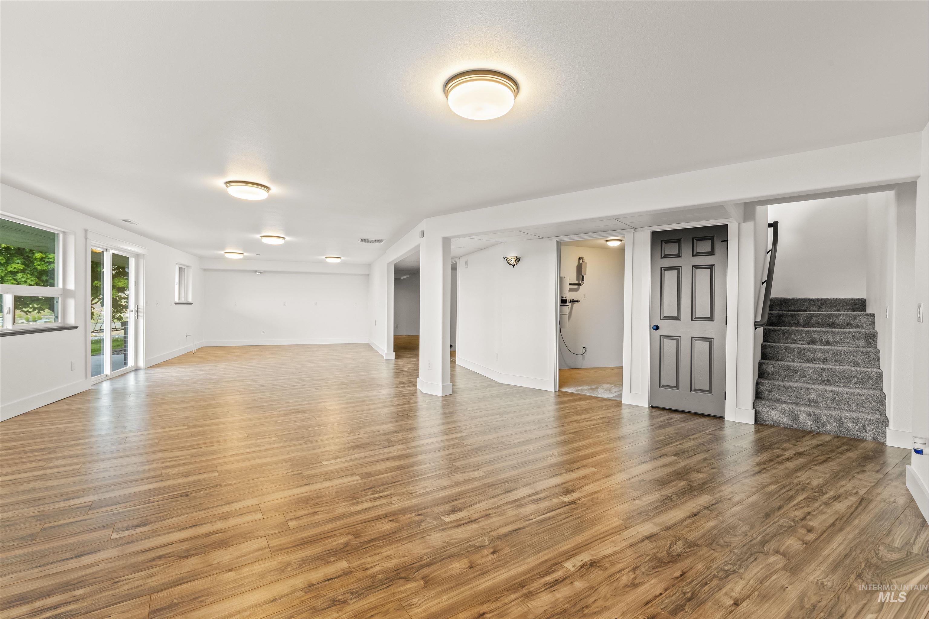 3360 East Main Street Lewiston, ID 83501 - Photo 37 of 50 Spacious room featuring wood-finish flooring, multiple flush-mount ceiling lights, and white walls