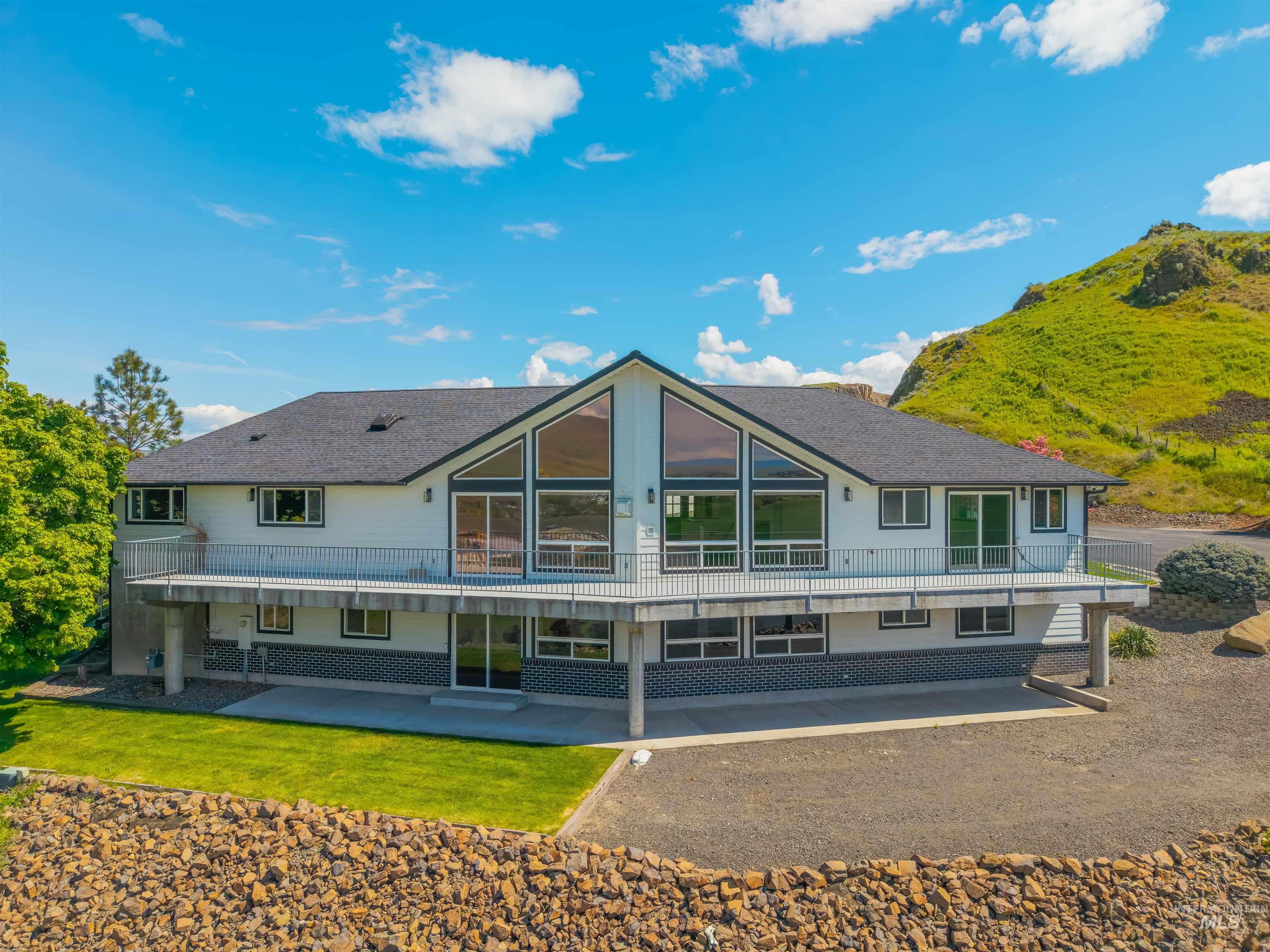 3360 East Main Street Lewiston, ID 83501 - Photo 4 of 50 Contemporary multi-level residence featuring a prominent gabled roofline and extensive upper-level balcony with metal railing