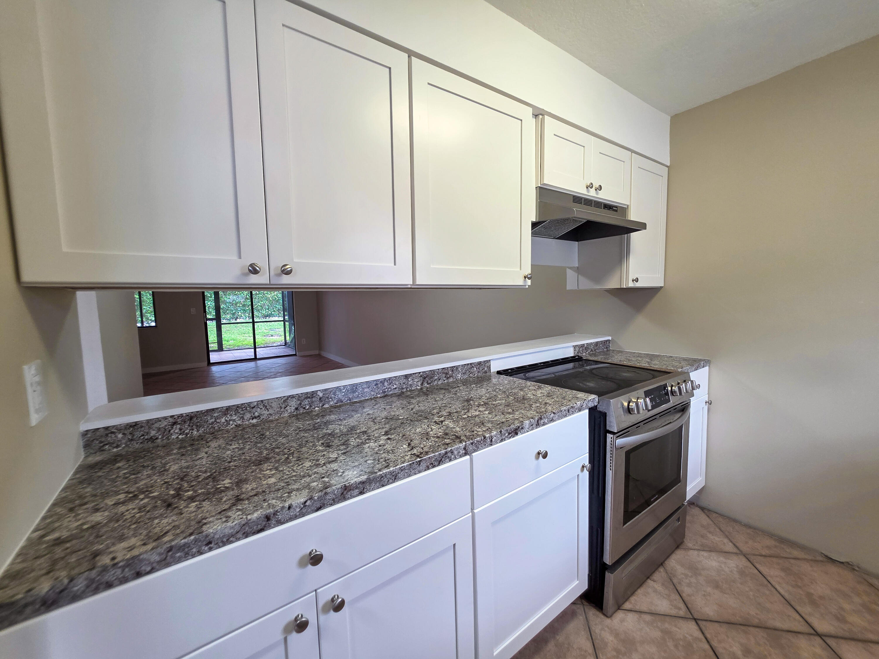 a kitchen with granite countertop a sink stainless steel appliances and cabinets