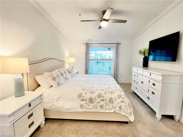 a bedroom with a bed window and a flat screen tv