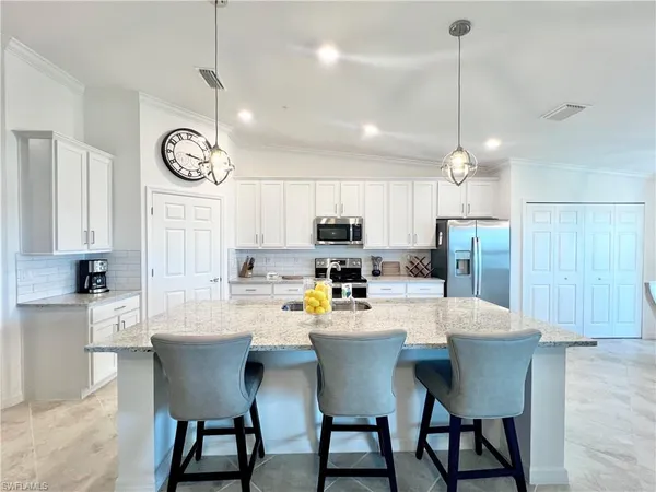 a kitchen with a dining table chairs refrigerator and cabinets