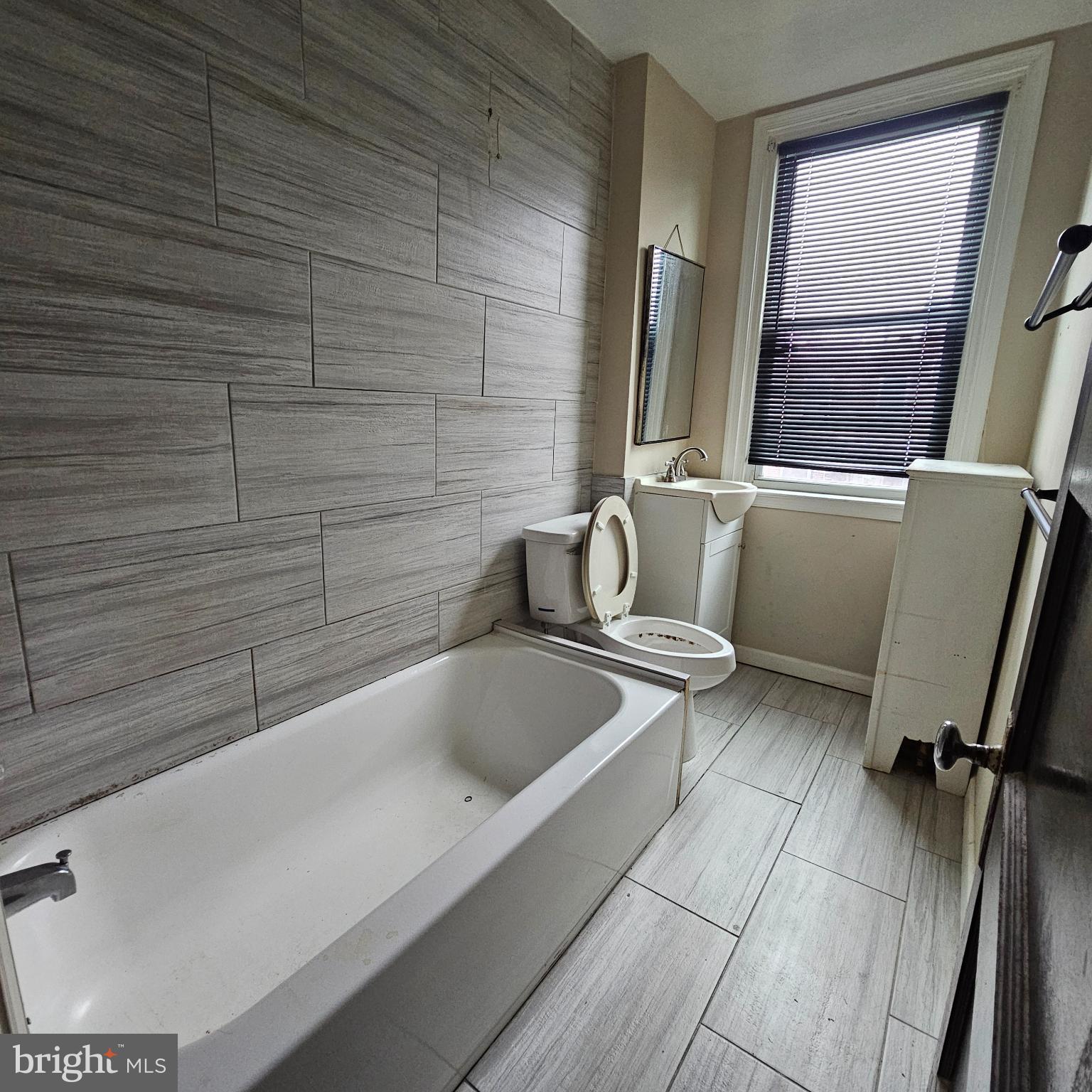 144 Fern Street Philadelphia, PA 19120 - Photo 12 of 12 a bathroom with a bathtub and a window