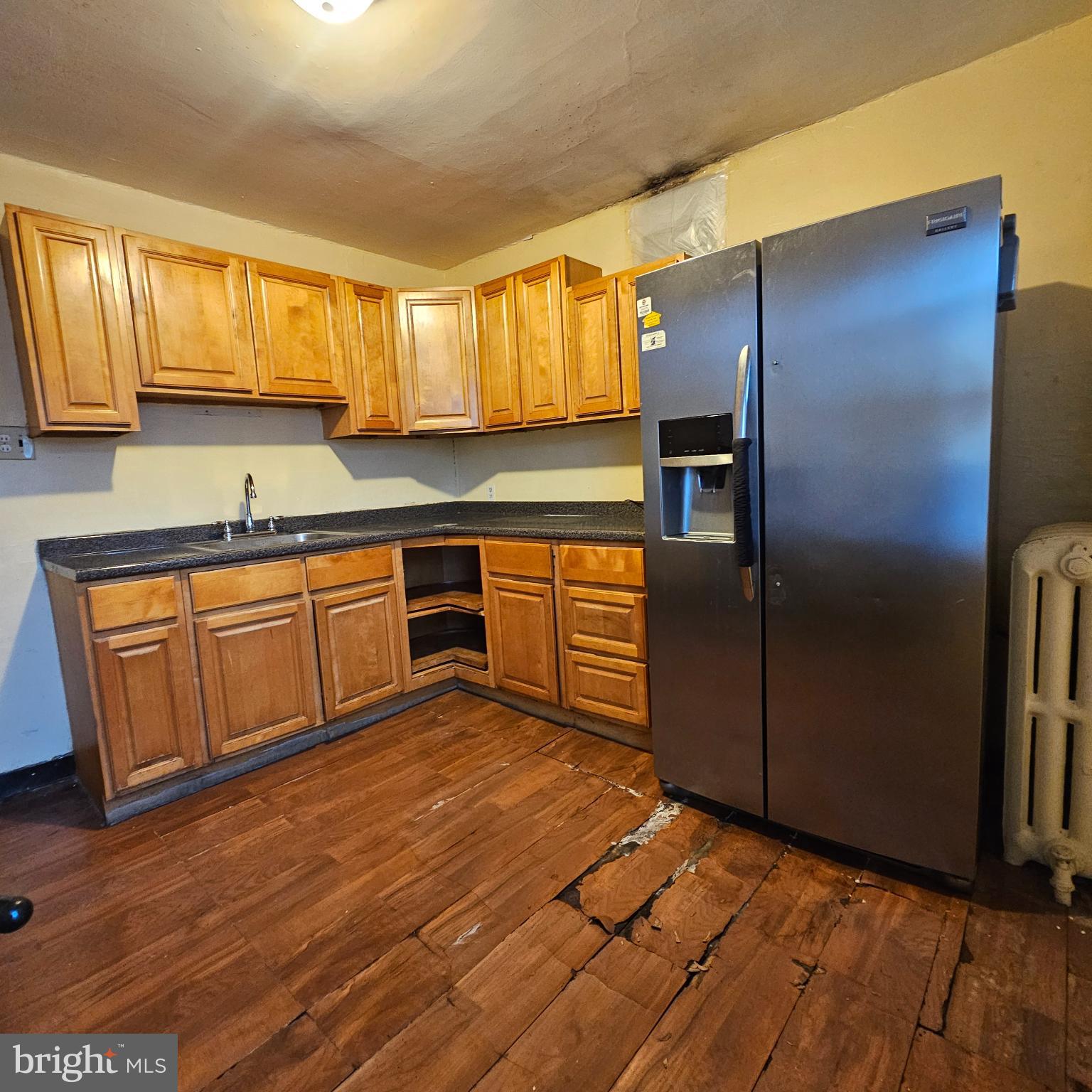 144 Fern Street Philadelphia, PA 19120 - Photo 6 of 12 a kitchen with stainless steel appliances granite countertop a refrigerator a sink dishwasher a stove with wooden cabinets and floor