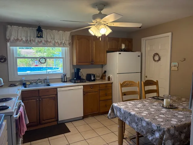 a kitchen with a table chairs and a refrigerator