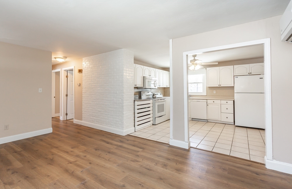 21 Sully Road Raynham, MA 02767 - Photo 10 of 22 an empty room with wooden floor and cabinet and kitchen view