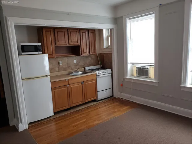 a kitchen with a refrigerator stove top oven sink and cabinets