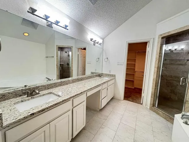 a large bathroom with a granite countertop sink two mirror and a shower