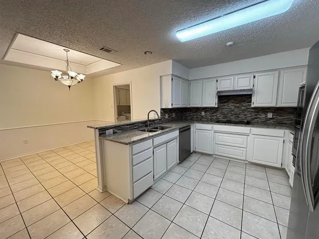 a kitchen with granite countertop a sink and cabinets