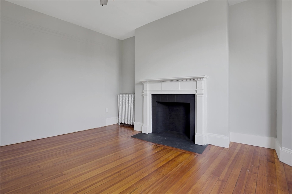 116 Winthrop Road, Unit 3 Brookline, MA 02445 - Photo 15 of 21 a view of an empty room with wooden floor and a fireplace