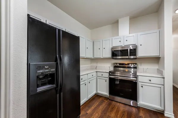 a kitchen with stainless steel appliances white cabinets and a refrigerator