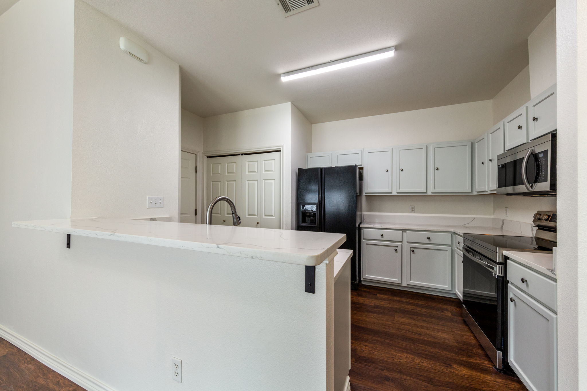 8708 Weiser Drive, Unit B Austin, TX 78729 - Photo 12 of 30 a kitchen with stainless steel appliances granite countertop a sink stove a refrigerator and a microwave