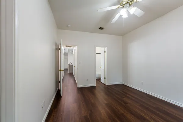 a view of an empty room with wooden floor