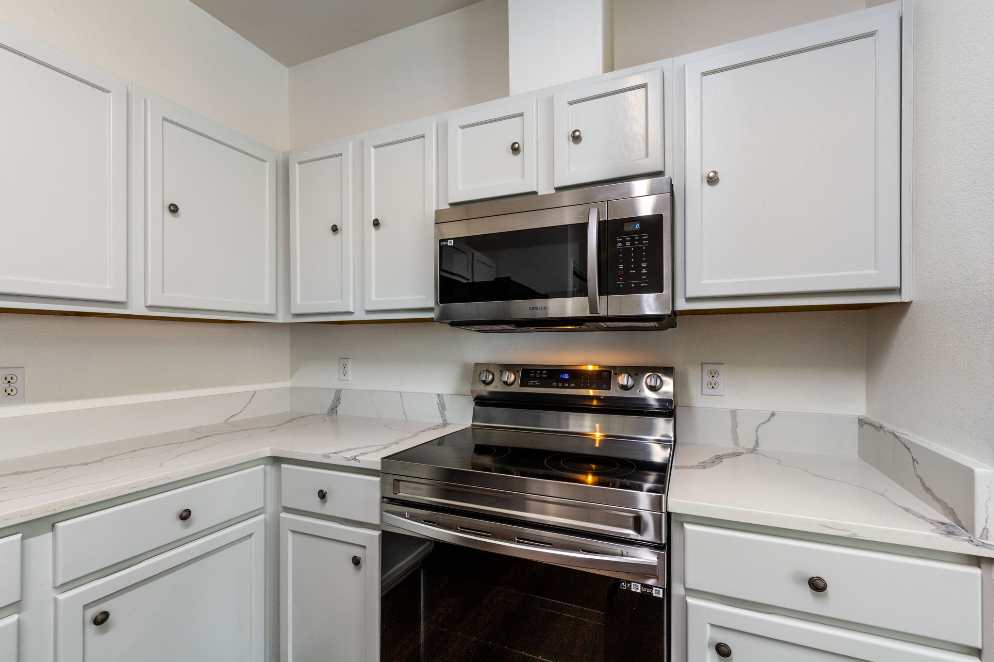 8708 Weiser Drive, Unit B Austin, TX 78729 - Photo 10 of 30 a kitchen with stainless steel appliances white cabinets and a stove top oven