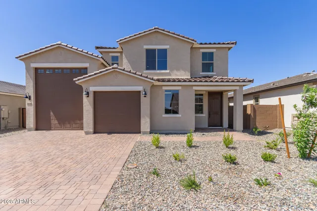 a front view of a house with a garden and yard