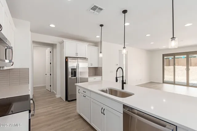 a kitchen with kitchen island a counter top space appliances and a ceiling fan