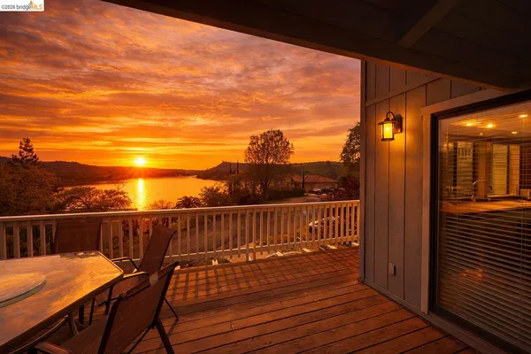 a view of a balcony with wooden floor and outdoor seating