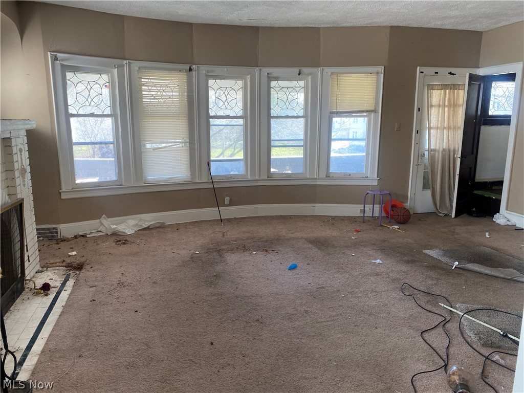 3634 Hildana Road Cleveland, OH 44120 - Photo 4 of 11 Upstairs Unfurnished living room featuring a healthy amount of sunlight, carpet, and a textured ceiling