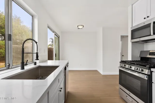 a kitchen with stainless steel appliances granite countertop a sink stove and refrigerator