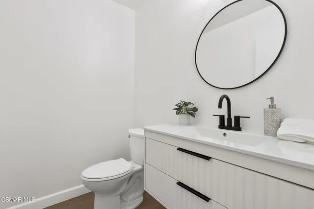 a bathroom with a sink mirror and toilet
