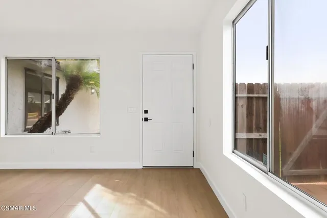 a view of a small space with wooden floor and a window
