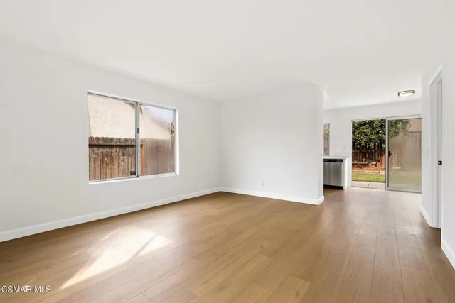 an empty room with wooden floor and a window