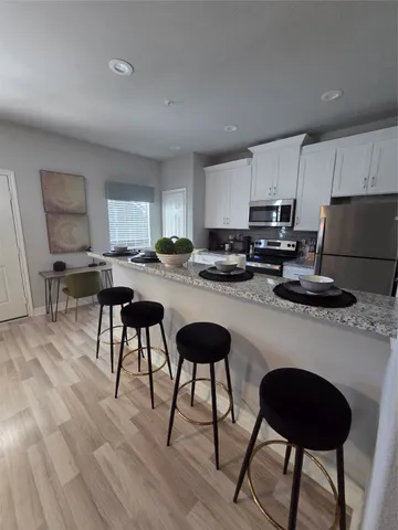 a kitchen with a dining table chairs microwave and sink