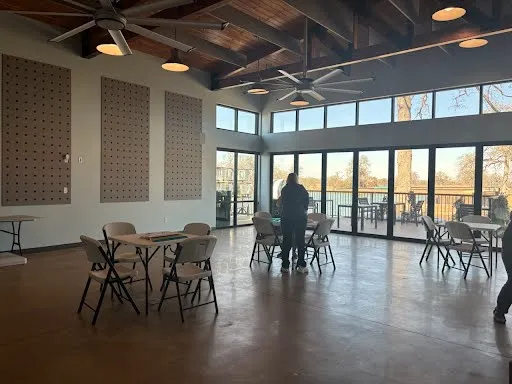 a dining room with furniture floor to ceiling windows and plants