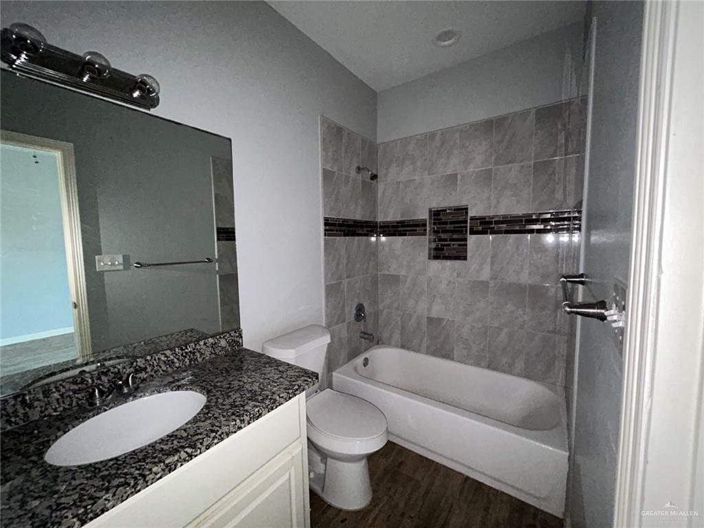 2100 Jackson Street, Unit 1 Weslaco, TX 78599 - Photo 6 of 13 a bathroom with a granite countertop sink toilet and shower