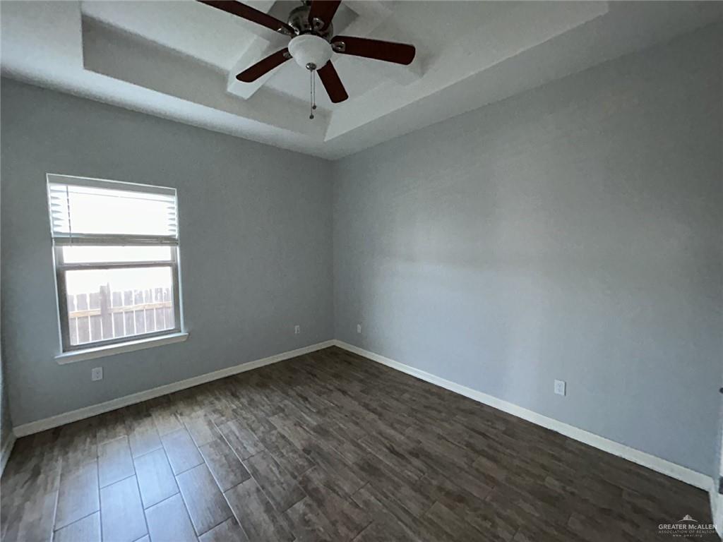 2100 Jackson Street, Unit 1 Weslaco, TX 78599 - Photo 7 of 13 an empty room with wooden floor ceiling fan and windows
