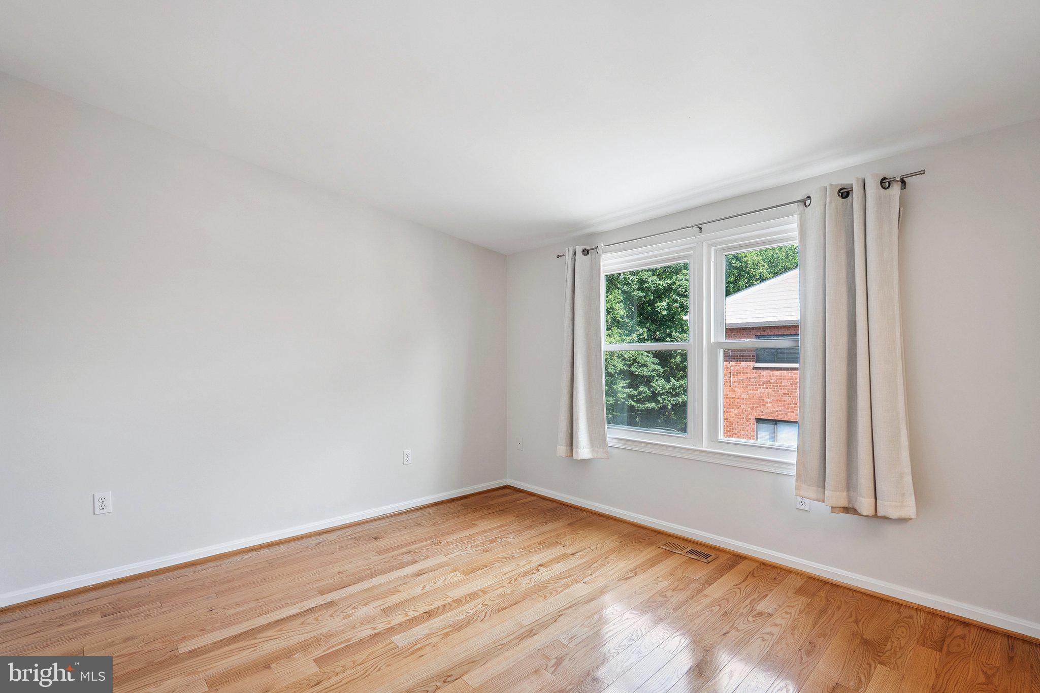 6861 Washington Boulevard Arlington, VA 22213 - Photo 13 of 28 a view of an empty room with wooden floor and a window