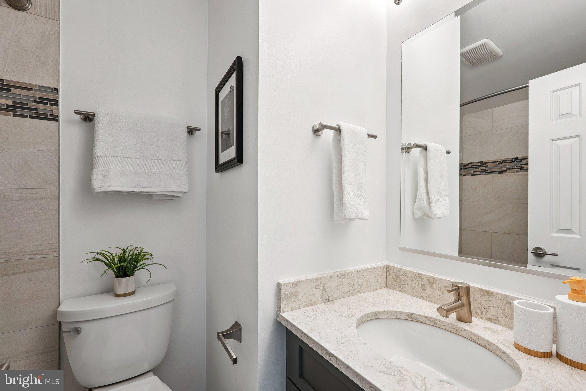 6861 Washington Boulevard Arlington, VA 22213 - Photo 16 of 28 a bathroom with a granite countertop sink and a mirror