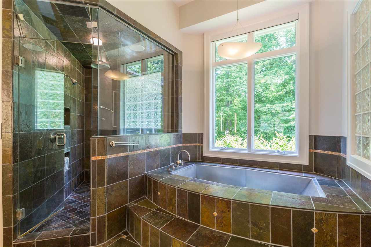 1117 Baslow Brook Court Raleigh, NC 27614 - Photo 19 of 30 A large walk-in shower is luxuriously wrapped in slate surround & provides a built-in seat, toiletry niches, traditional shower head, rain shower head & handheld shower head. Enjoy a soothing bath in a ergonomically curved stainless steel garden tub. Master Shower and Stainless Steel Tub