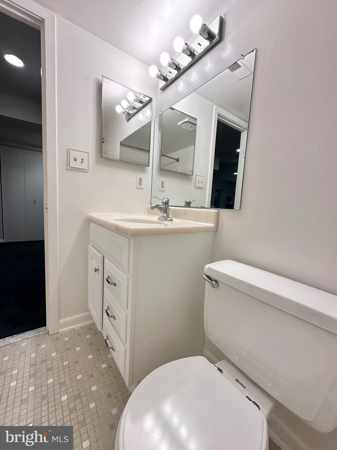 2021 Lakebreeze Way Reston, VA 20191 - Photo 45 of 51 a bathroom with a sink a toilet a mirror and vanity