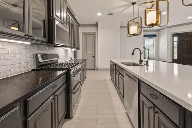 a kitchen with stainless steel appliances a sink stove top oven and cabinets