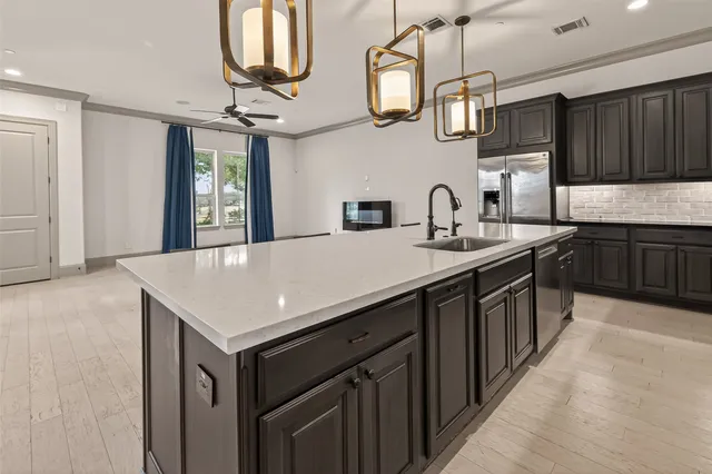 a kitchen with stainless steel appliances granite countertop a sink a stove and cabinets