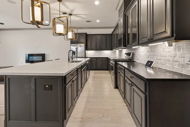 a kitchen with stainless steel appliances a sink stove and cabinets