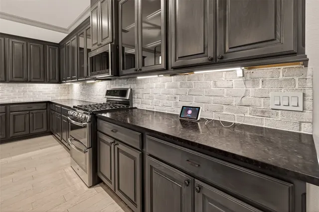 a kitchen with stainless steel appliances granite countertop a sink stove and cabinets