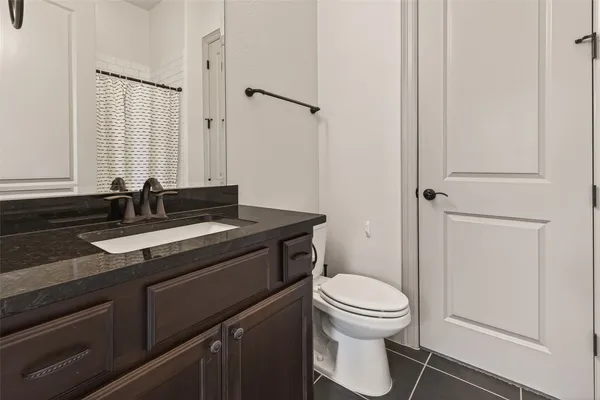 an empty room with chandelier fan and windows