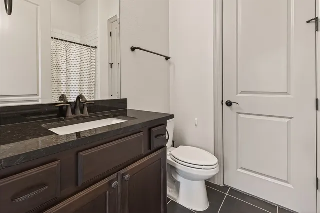 an empty room with chandelier fan and windows