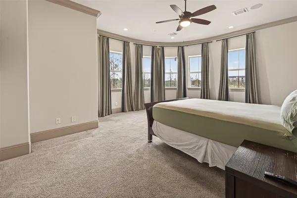 a bedroom with a bed and a large window